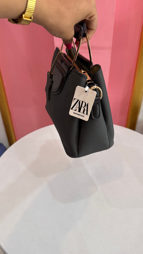کیف دستی زنانه چرمی مشکی با دسته فلزی طلایی و طراحی مدرن کد ۵۷۷