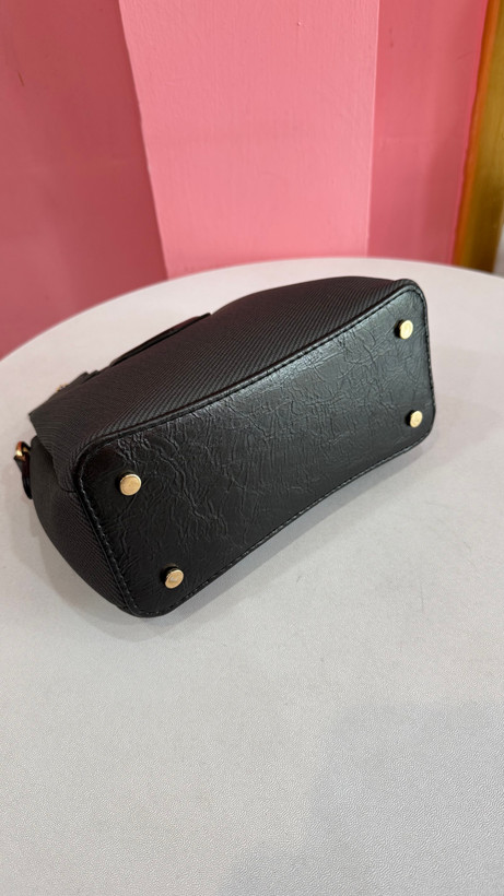 کیف دستی زنانه چرمی مشکی با دسته فلزی طلایی و طراحی مدرن کد ۵۷۷
